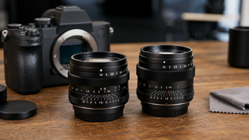 35mm and 50mm manual prime lenses compared on a photography desk